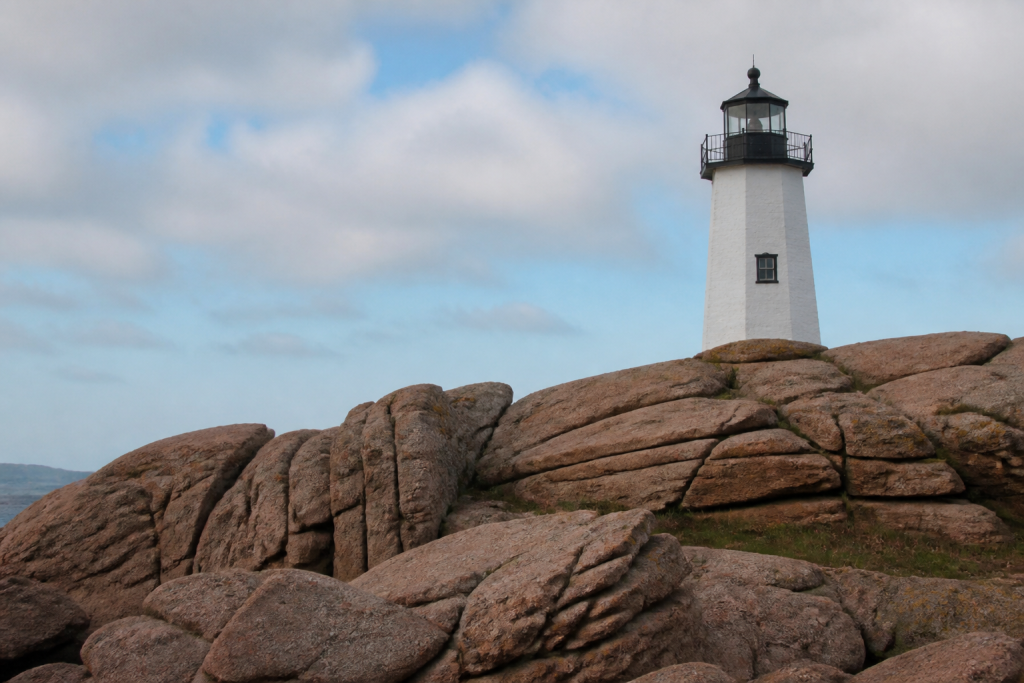Phare blanc surplombant bloc granite rose littoral